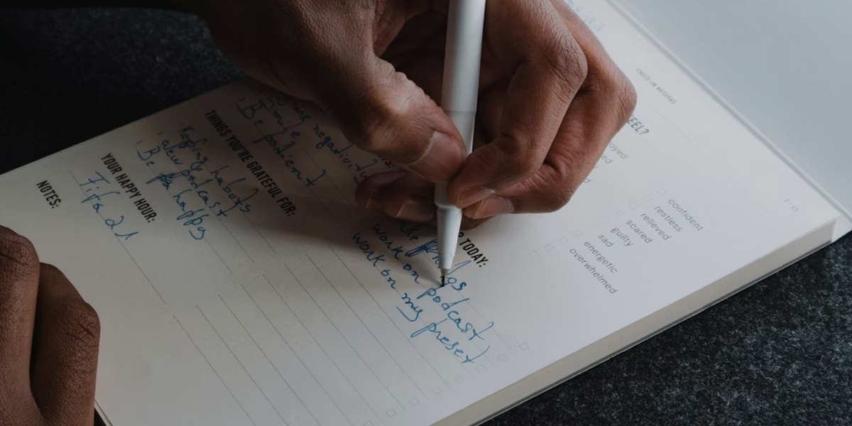 A person writing in their journal setting their intentions